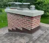 A red brick chimney on the roof of a house.