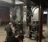 Two workers servicing an HVAC in a basement.