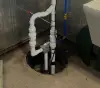 A plumbing system in the floor of a basement.