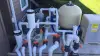 A complex pool pump and filtration system with white PVC pipes and various valves outdoors.