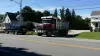A CNY Sealing truck leaving a driveway in a residential neighborhood.