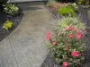 A new slate walkway with pink flowers along the path.