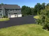 A newly paved driveway and a blue house