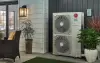Outdoor LG air conditioning unit beside plants and patio furniture near a house entrance.