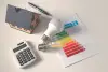energy assesment with lightbulbs, a pen, home model, and calculator