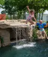 backyard pool party with waterfall