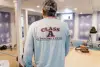 A man in a Class A Construction shirt stands in a room under renovation.
