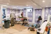 Two people work on carpentry in an unfinished basement with tools and construction materials.