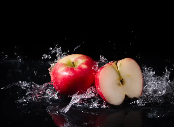 Dramatic apple product photography with water splash