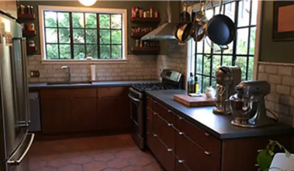 kitchen with dark countertops and light tile backsplash by class a construction